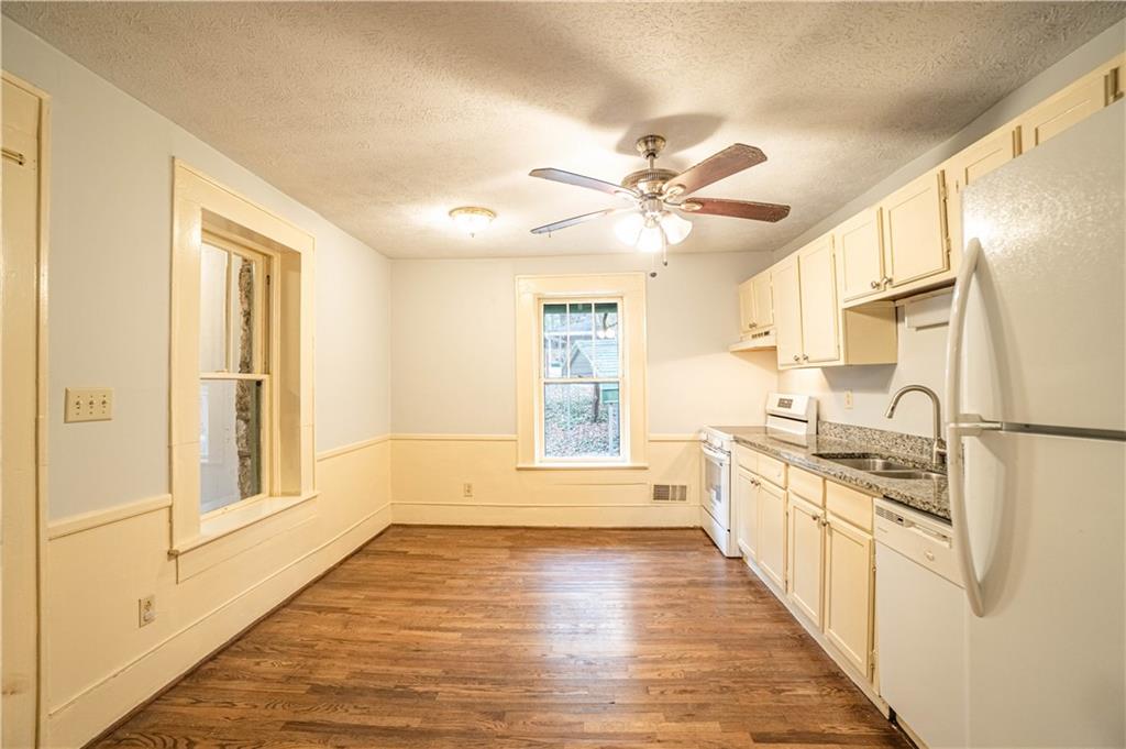 1865 Oak Grove Road Northeast Atlanta, GA 30345 - Photo 10 of 17 a kitchen with stainless steel appliances a stove top oven a refrigerator a sink and dishwasher with white cabinets