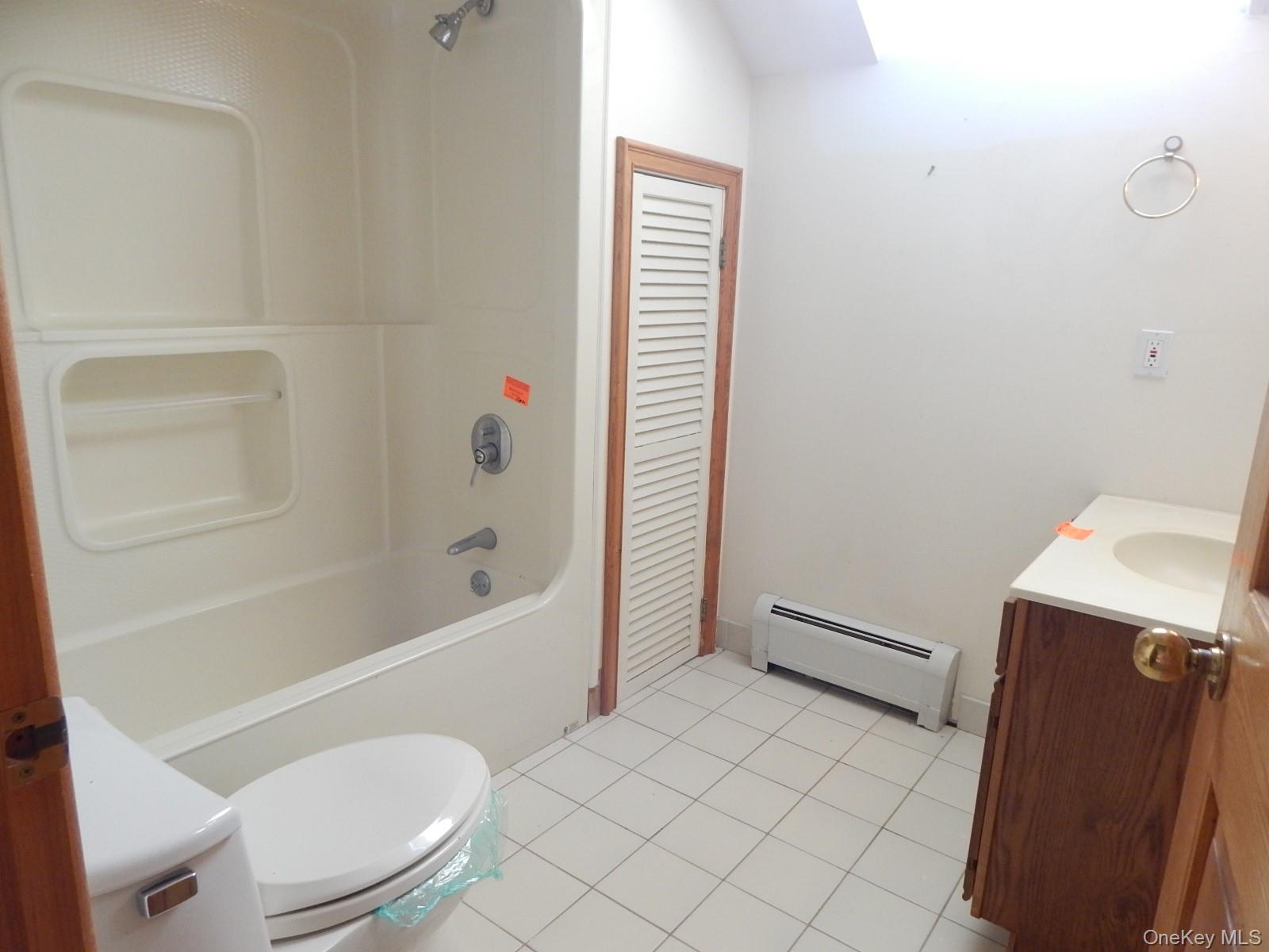 5 Eagle Head Road Cornwall-on-Hudson, NY 12520 - Photo 14 of 24 Bathroom with vanity, baseboard heating, bathing tub / shower combination, and light tile patterned floors