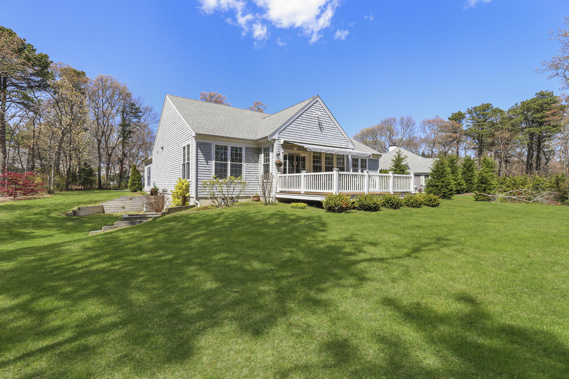25 Dacey Drive Centerville, MA 02632 - Photo 35 of 40 a front view of a house with a yard table and chairs