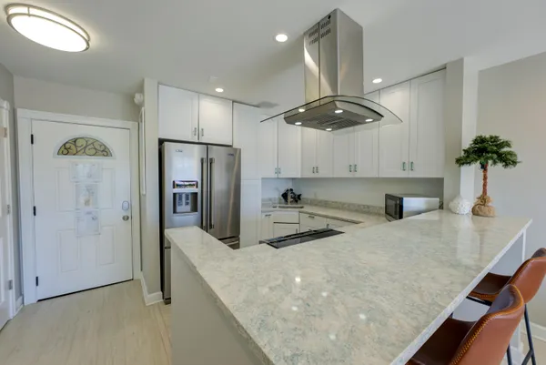a kitchen with stainless steel appliances granite countertop a sink a stove and a refrigerator