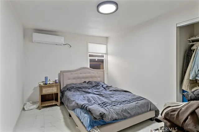 a bedroom with a bed and a flat screen tv