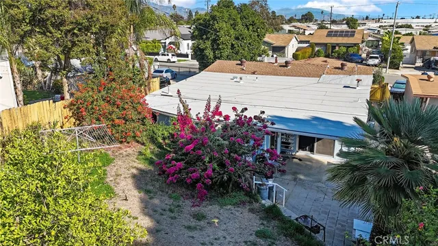 an aerial view of a house with a yard and wooden fence