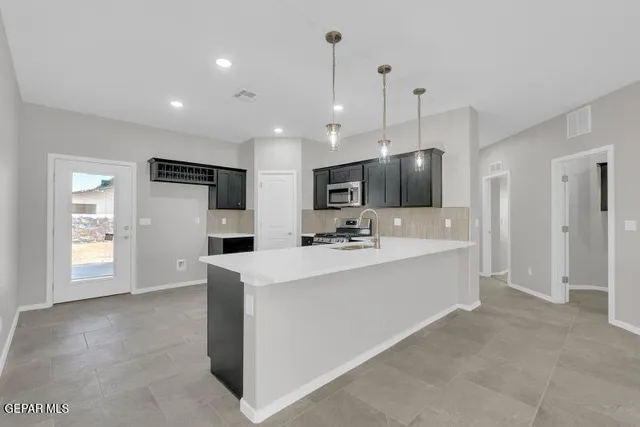 a view of kitchen with kitchen island a sink and a stove