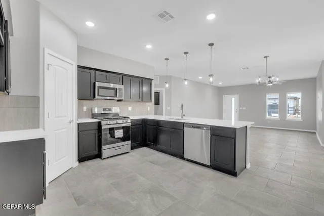 a kitchen with stainless steel appliances granite countertop a stove a sink and a refrigerator