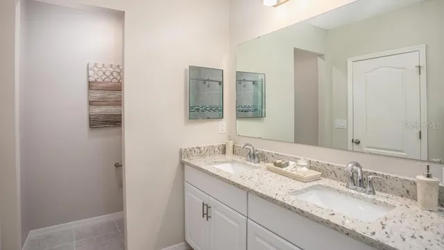 a bathroom with a granite countertop sink and a mirror