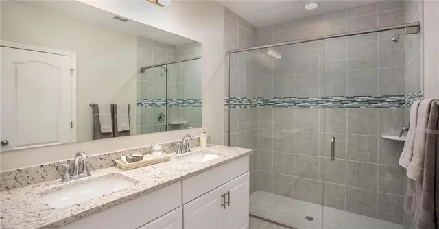 a bathroom with a granite countertop shower sink and mirror