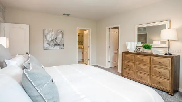 a bedroom with a bed and a mirror on dresser
