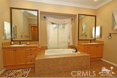a spacious bathroom with a tub sink and mirror