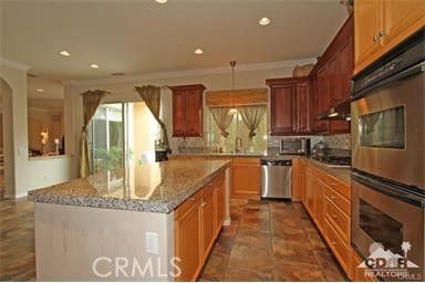 a kitchen with stainless steel appliances granite countertop a sink a stove and a refrigerator