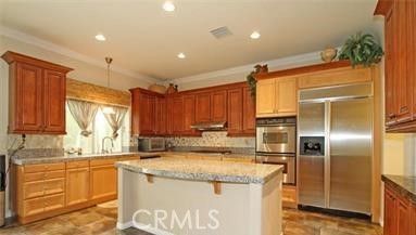 a kitchen with granite countertop a refrigerator a sink a stove and cabinets