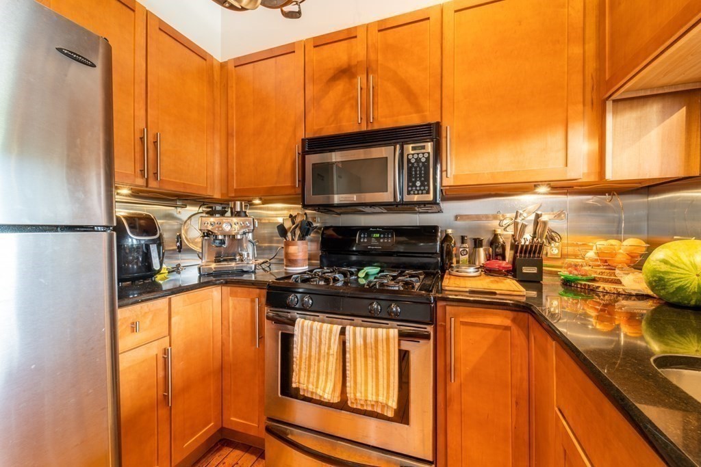 1 Envelope Terrace, Unit 309 Worcester, MA 01604 - Photo 6 of 18 a kitchen with stainless steel appliances granite countertop a stove a sink and a microwave