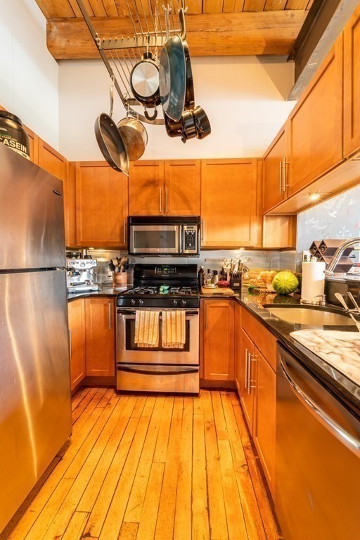 1 Envelope Terrace, Unit 309 Worcester, MA 01604 - Photo 7 of 18 a kitchen with stainless steel appliances granite countertop a refrigerator a stove and a wooden floors
