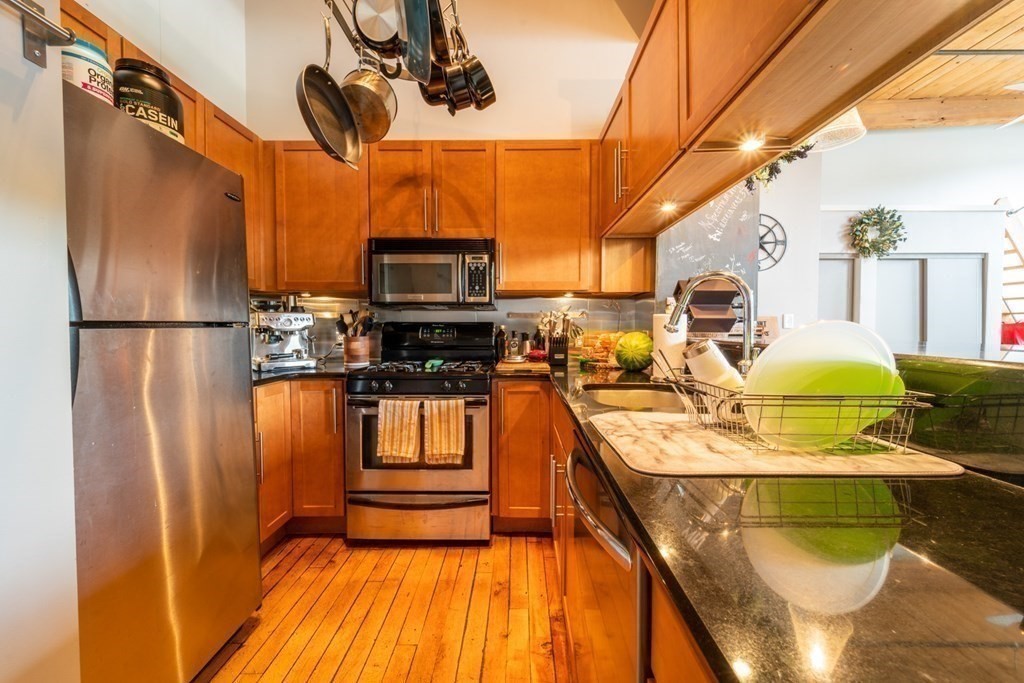 1 Envelope Terrace, Unit 309 Worcester, MA 01604 - Photo 8 of 18 a kitchen with stainless steel appliances granite countertop a sink a stove top oven a chimney and a refrigerator