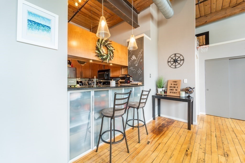 1 Envelope Terrace, Unit 309 Worcester, MA 01604 - Photo 9 of 18 a kitchen with stainless steel appliances kitchen island granite countertop a table and chairs in it