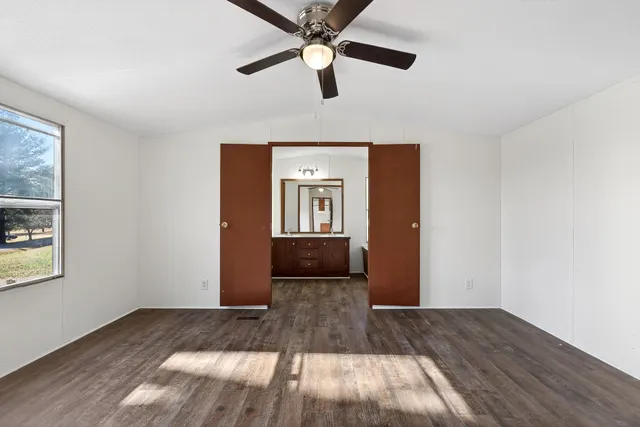 a view of a livingroom with a ceiling fan and wooden floor