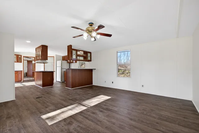 a view of a livingroom with wooden floor and a ceiling fan
