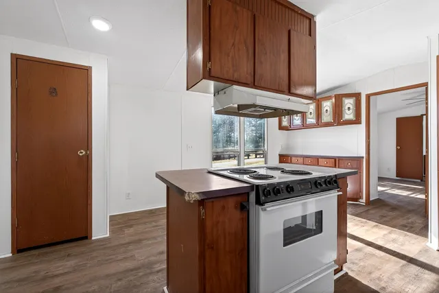 a kitchen with a stove and a wooden floors