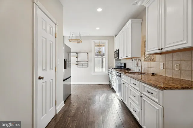 a large kitchen with granite countertop a lot of counter space and wooden floor