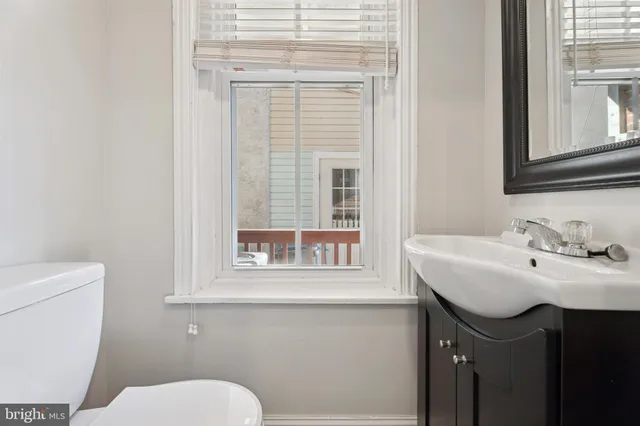 a bathroom with a sink a toilet and a window