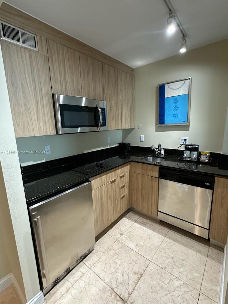 2670 East Sunrise Boulevard, Unit 905 Fort Lauderdale, FL 33304 - Photo 28 of 58 a kitchen with granite countertop a sink and a stove top oven
