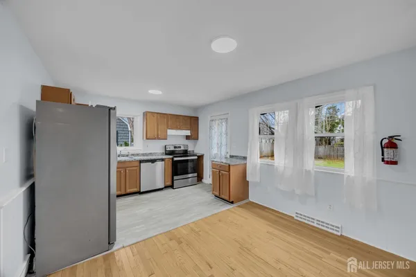 a large kitchen with a refrigerator a stove top oven a sink dishwasher and wooden cabinets