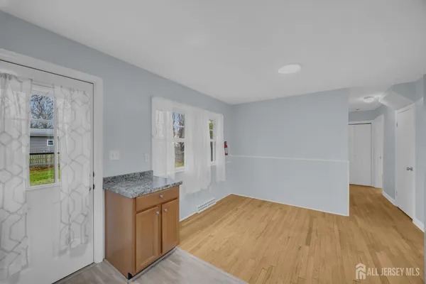 an empty room with wooden floor and cabinet