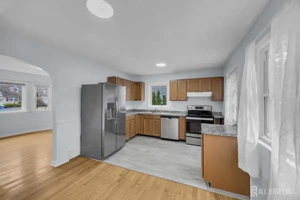 a kitchen with stainless steel appliances granite countertop a refrigerator a stove top oven a sink and dishwasher