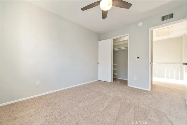 an empty room with chandelier fan