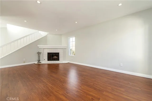 an empty room with wooden floor and fireplace
