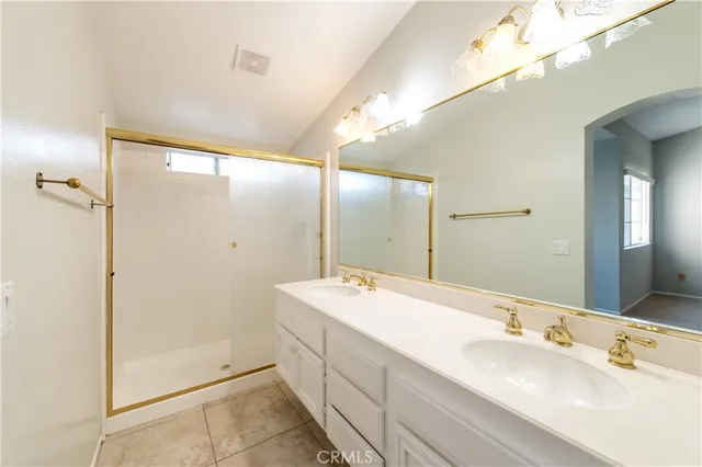 a bathroom with a double vanity sink mirror and shower