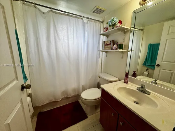 a bathroom with a sink a toilet and shower curtain