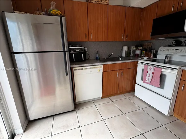 a kitchen with stainless steel appliances granite countertop a refrigerator stove a sink and dishwasher