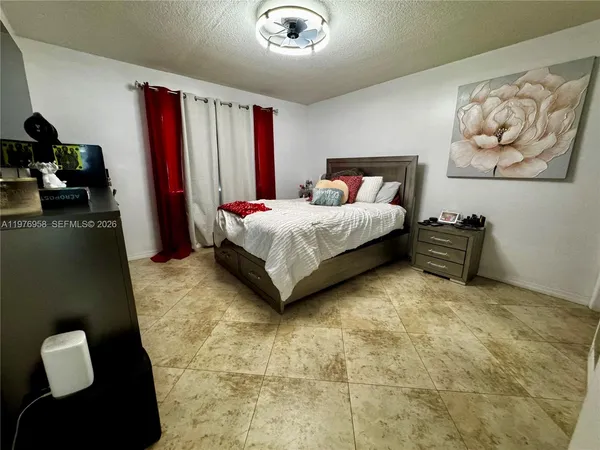 a spacious bedroom with a bed and a painting on the wall