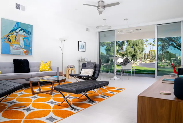 a living room with patio furniture and a floor to ceiling window