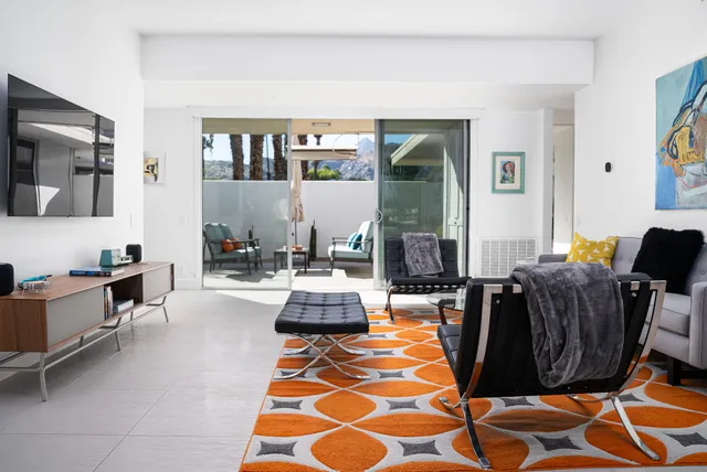 a living room with furniture a rug and a flat screen tv