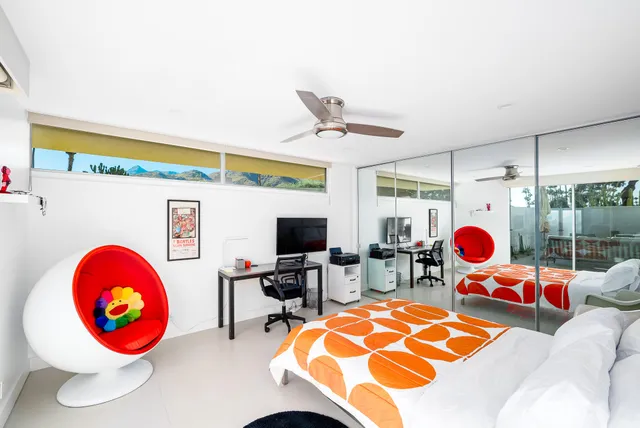 a living room with furniture a flat screen tv and a floor to ceiling window