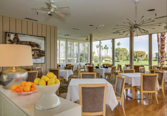 a living room with furniture a flat screen tv and a large window