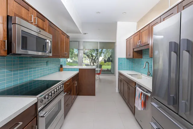 a kitchen with stainless steel appliances granite countertop a sink and a stove