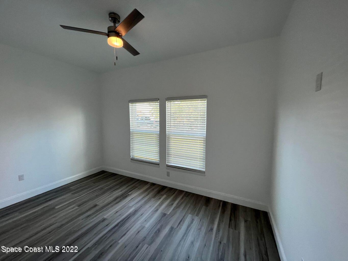 2498 Mitchell Avenue Mims, FL 32754 - Photo 15 of 18 an empty room with wooden floor ceiling fan and window