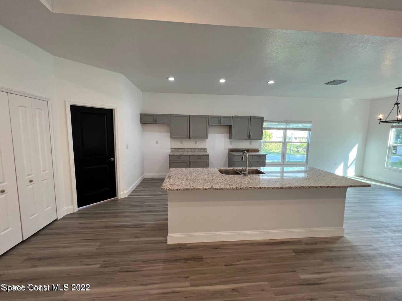 2498 Mitchell Avenue Mims, FL 32754 - Photo 3 of 18 a large white kitchen with kitchen island a sink wooden floor and a refrigerator