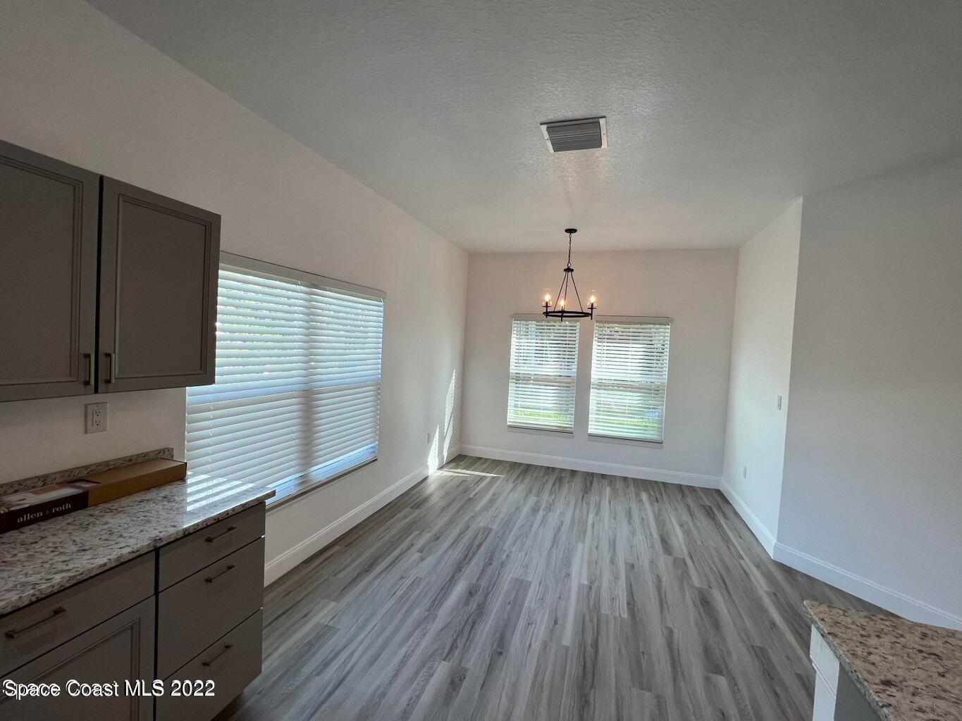 2498 Mitchell Avenue Mims, FL 32754 - Photo 7 of 18 a view of an empty room with wooden floor and a window