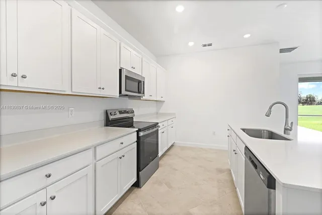 a kitchen with stainless steel appliances granite countertop a sink and a stove top oven