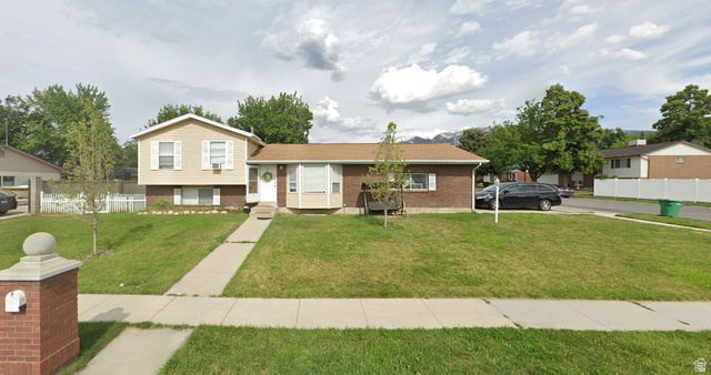 9571 David Street, Unit UPSTR Sandy, UT 84070 - Photo 1 of 13 Split-level residence featuring a brick and siding exterior, front yard with mature landscaping, and a paved walkway leading to the front entry