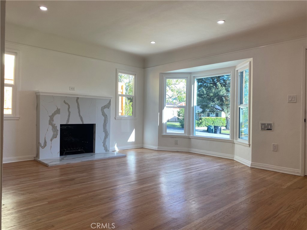 775 Morada Place Altadena, CA 91001 - Photo 12 of 32 an empty room with wooden floor fireplace and windows