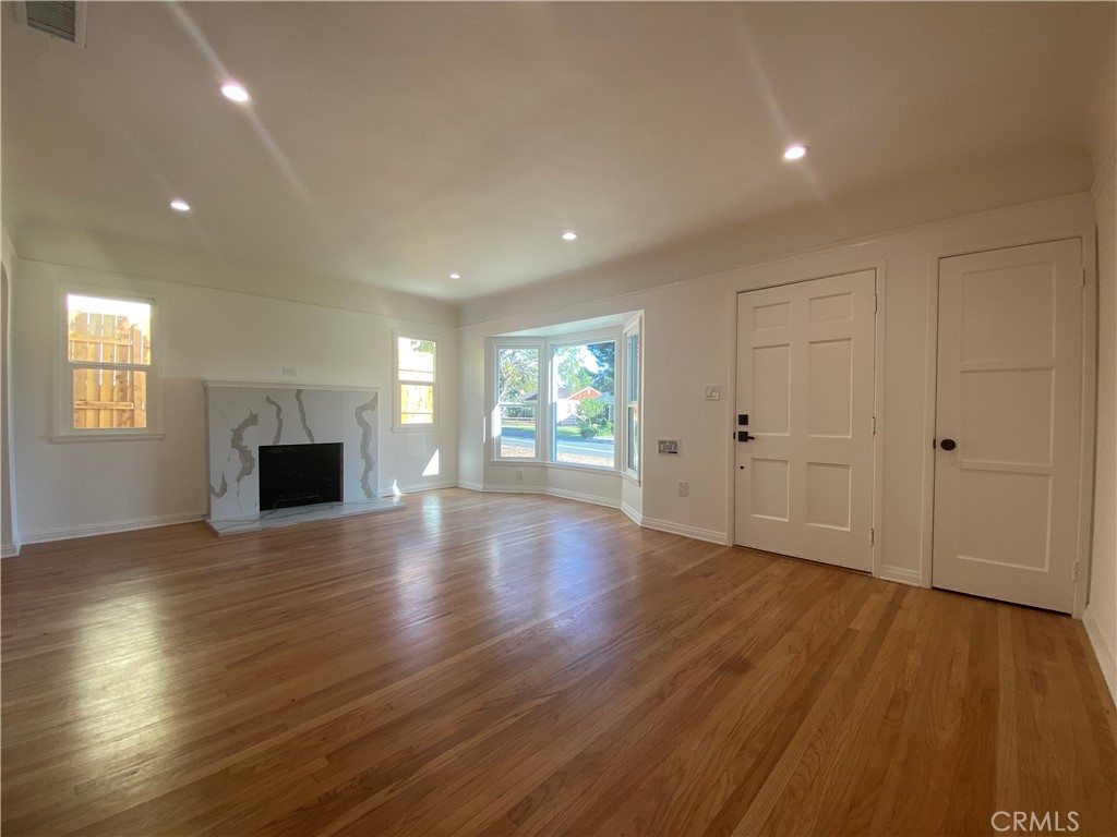 775 Morada Place Altadena, CA 91001 - Photo 13 of 32 an empty room with wooden floor and fireplace