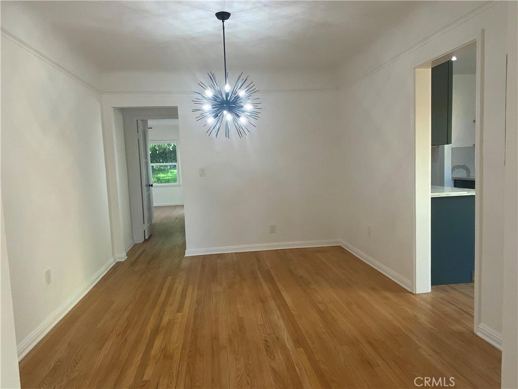 775 Morada Place Altadena, CA 91001 - Photo 19 of 32 an empty room with chandelier fan and wooden floor