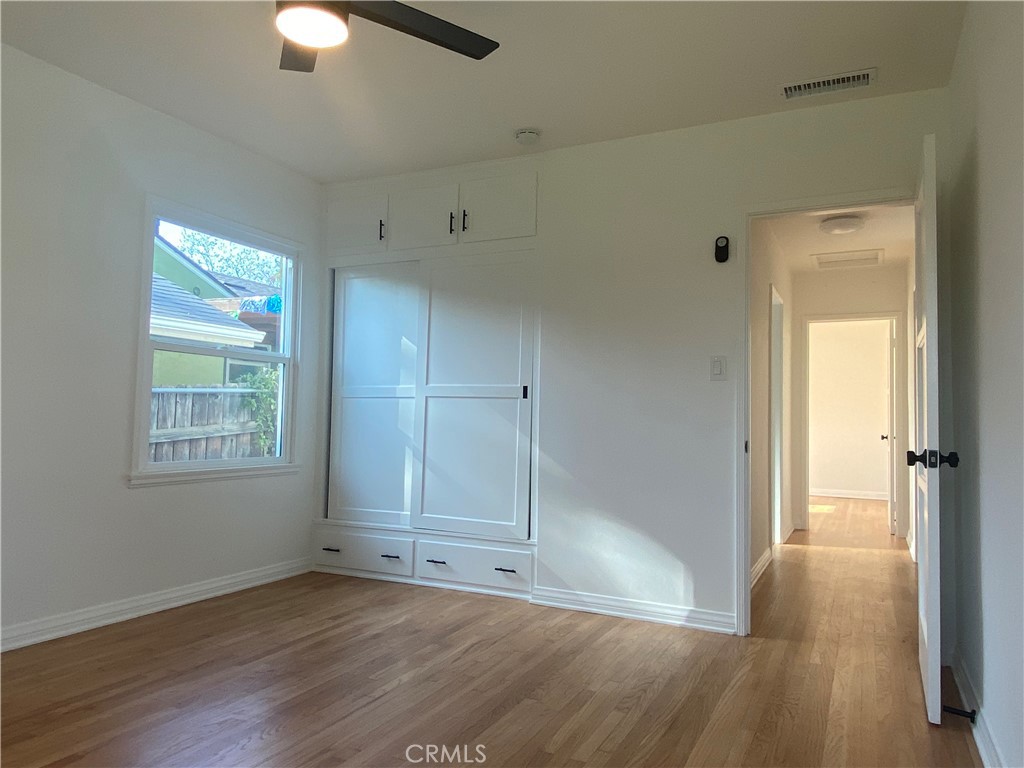 775 Morada Place Altadena, CA 91001 - Photo 21 of 32 an empty room with wooden floor cabinet and windows