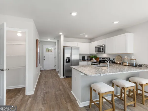 a kitchen with granite countertop a refrigerator and a sink