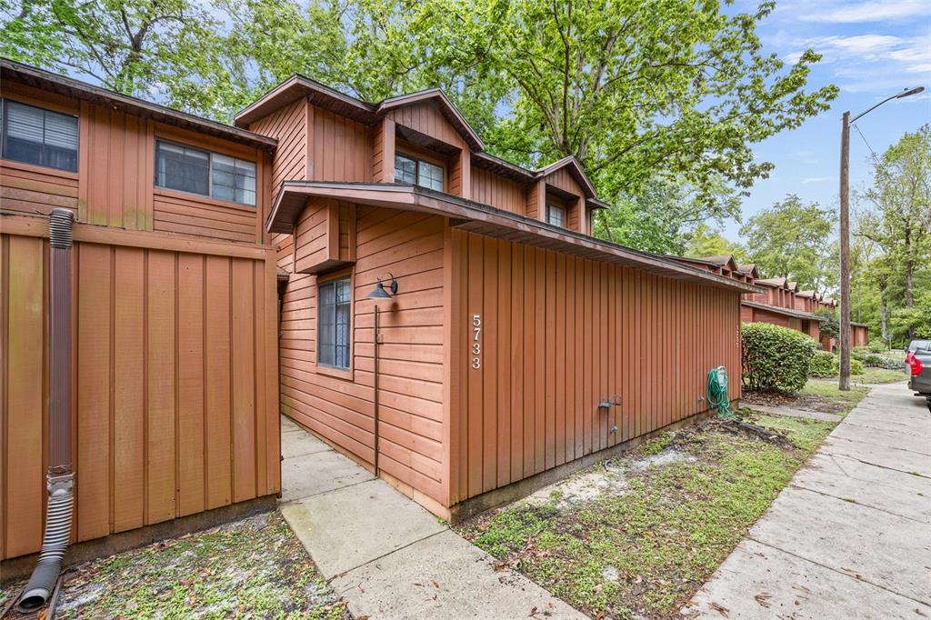 a view of a small house with wooden fence