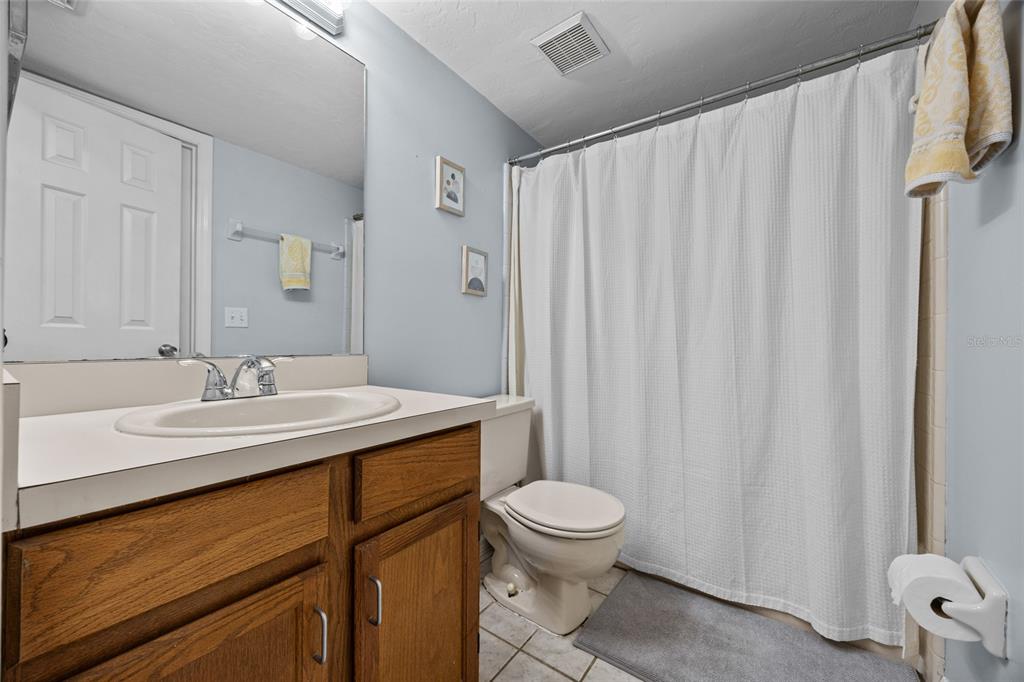 5733 Southwest 10th Place Gainesville, FL 32607 - Photo 19 of 23 a bathroom with a sink a toilet and shower curtain
